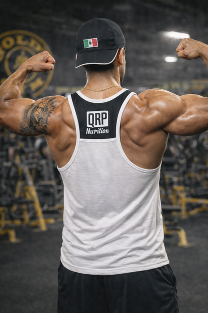 Muscular individual wearing a white tank top with 'QRP Nutrition' branding, flexing muscles in a gym setting.